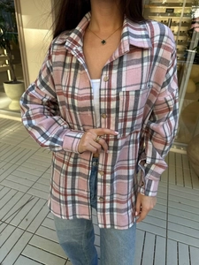 Detail of classic pink and grey plaid flannel shirt featuring a front pocket and soft texture