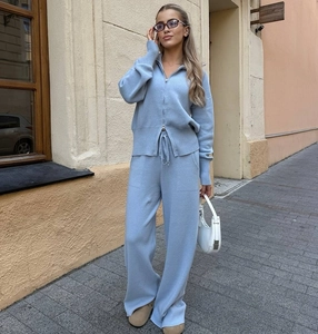 Dettaglio del set due pezzi in maglia azzurra con cardigan a zip metallica e pantaloni larghi