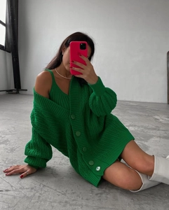 Close-up of green cable-knit cardigan and matching V-neck tank top set with round buttons