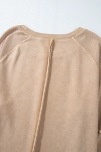 Close-up of khaki waffle knit texture and vintage stitching on long sleeve top