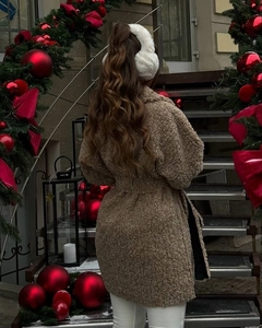 Detailed back view of a plush brown teddy coat with warm fabric in a festive setting
