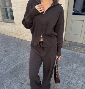 Dettaglio completo di set in maglia marrone scuro con cerniera a due vie e polsini