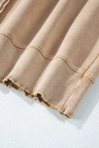 Detailed close-up of khaki knit fabric featuring ribbed hem and double-needle stitching