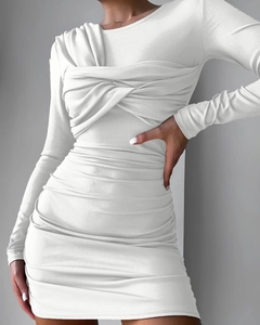 Close-up of ruched detailing and twisted chest design on a white slim long sleeve dress