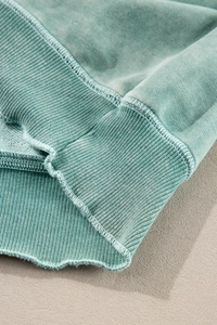 Detailed macro view of washed green French Terry fabric with ribbed cuffs texture