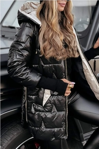 Détail d'une parka matelassée noire brillante avec poignets coupe-vent et zips latéraux