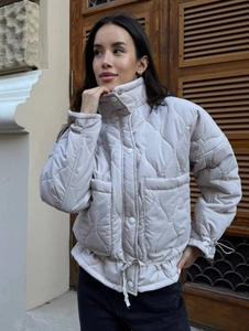 Women's beige quilted puffer jacket with stand collar and drawstring waist for winter