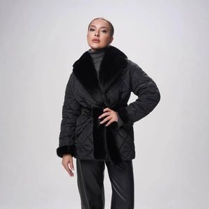 Détail d'une veste matelassée noire avec col en fausse fourrure et ceinture nouée