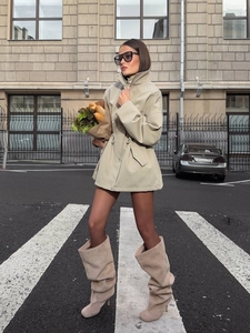 Detail of sand khaki trench coat featuring adjustable drawstring waist and large flap pockets