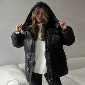 Close-up of black glossy padded jacket featuring drawstring waist and hooded design