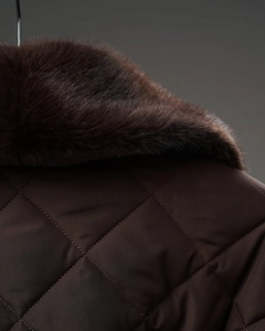 Vue détaillée du manteau matelassé marron foncé avec un col en fourrure véritable de luxe