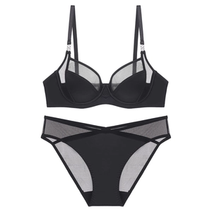 Detail view of black sheer mesh lingerie set with smooth fabric and metal hardware