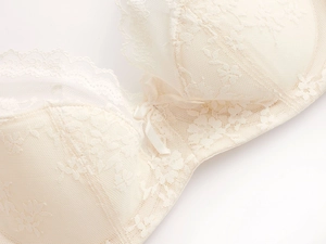 Detailed close-up of ivory floral lace and eyelash lace trim on a soft cup bra