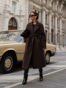 Detail of elegant dark brown wool coat with waist tie belt and large side pockets