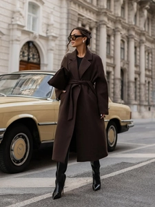 Detailed view of the dark brown wool coat featuring a waist tie and classic lapel collar