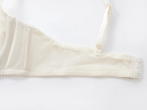 Detail view of cream white lace bra with breathable mesh wings and adjustable strap