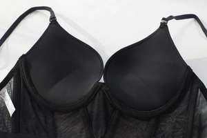 Detalle de copas moldeadas lisas y paneles de malla transparente de un sujetador negro