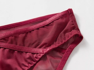 Close-up of semi-transparent wine red mesh and silk satin fabric with wavy edge stitching