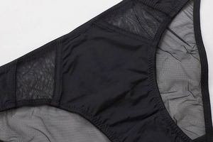 Vista macro detallada de patchwork de malla negra y costuras en zigzag en bragas de mujer