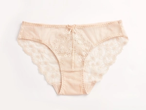 Detalle de braga de encaje nude con bordado floral delicado y un pequeño lazo frontal