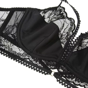 Detailed close-up of the delicate black lace and gold metal ring on the bra strap