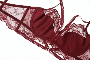 Close-up of wine red lace bra featuring scalloped edges and intricate floral patterns