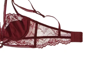 Detail of burgundy floral lace bra featuring scallop edges and adjustable straps