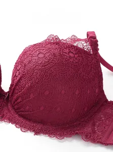 Detalle de sujetador de encaje rojo vino con patrones florales y bordes de encaje de pestañas