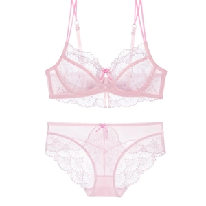 Detailansicht eines hellrosa Spitzen-Dessous-Sets mit Stickerei und Schleifen-Details