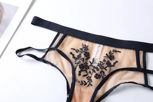 Gros plan détaillé de la culotte en résille taille haute avec broderie florale noire complexe