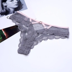 Détail de string en dentelle grise avec boucle cœur en métal et bretelles roses