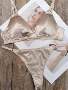 Ensemble de lingerie en satin champagne avec soutien-gorge triangle et string sur bois