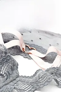 Détail de string en dentelle avec bride élastique rose et anneau en métal doré en cœur