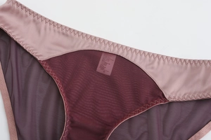 Détail de maille bordeaux et satin rose avec coutures en zigzag sur une culotte femme