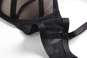 Detailed macro view of black mesh fabric and elastic strap with metal adjustment buckle