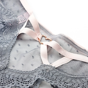 Détail de la dentelle florale et de la boucle en métal doré rose sur le string taille basse