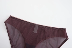 Gros plan sur la maille semi-transparente et les coutures ondulées du slip violet