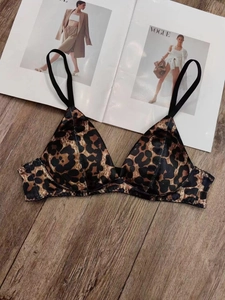 Bralette de satén con estampado de leopardo y tirantes negros sobre una revista de moda