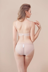 Vista trasera detallada del conjunto de lencería de encaje rosa nude con tiras en U y lunares