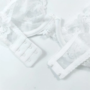 Close-up of white floral lace bra featuring a three-row hook-and-eye back closure