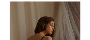 Detail of elegant black lace bra with thin straps worn by a model in soft indoor lighting
