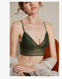 Gros plan sur la bralette en dentelle vert foncé avec nœud et châle blanc transparent