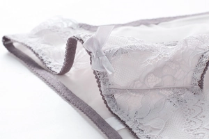 Gedetailleerde macro-opname van witte kanten lingerie met een satijnen strik en fijne textuur