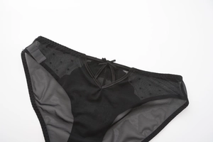 Detail of black mesh lace panties featuring a cutout V-cross design and a small bow