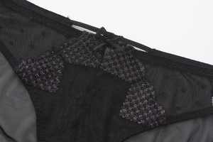 Close-up of black mesh panties with purple embroidery and a small bow detail