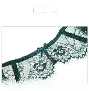 Detailed macro view of dark green eyelash lace garter belt with a satin ribbon bow