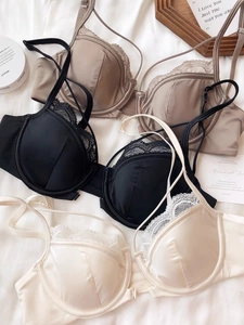 Detail of elegant satin lace bras in black, champagne, and pink with eyelash lace trim