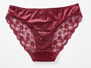 Detailed view of burgundy satin panties with intricate floral lace and scallop edges