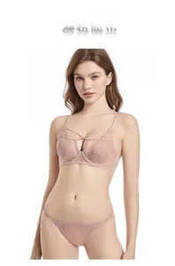 Close-up of pink floral lace embroidery and criss-cross straps on a luxury bra set