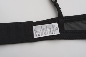Detail view of the laundry care label and seam stitching on black lace bra